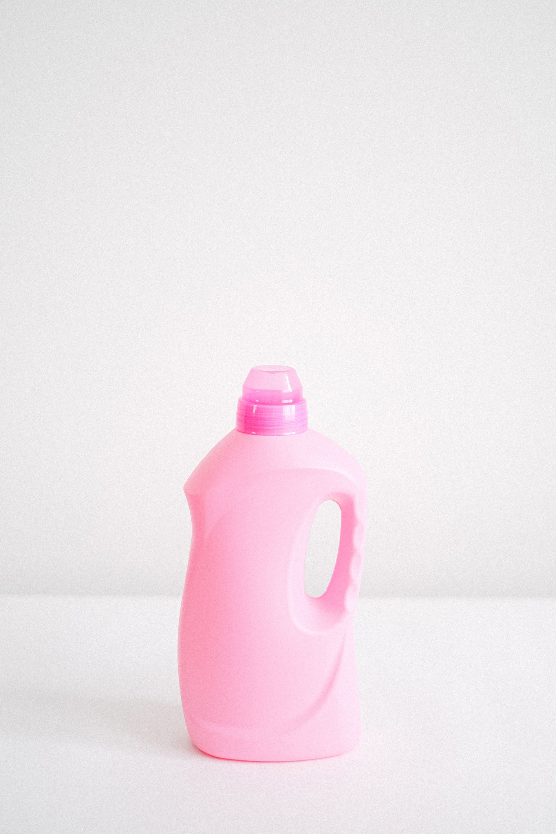 Plastic bottle of fabric softener chemical liquid for washing and household chores against white background